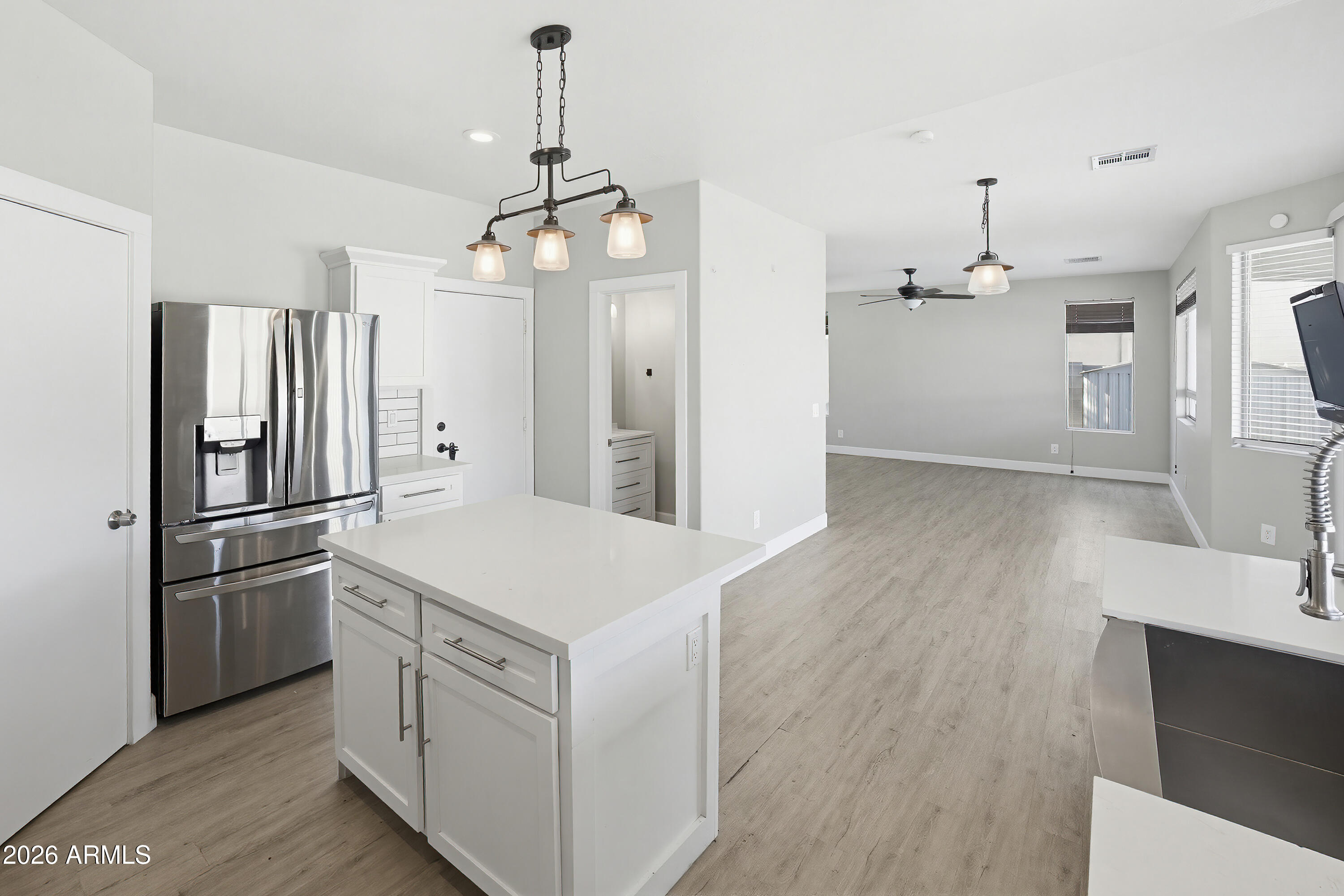 3818 West Carson Road Phoenix, AZ 85041 - Photo 14 of 41 a kitchen with stainless steel appliances a refrigerator a sink dishwasher a stove and white cabinets with wooden floor