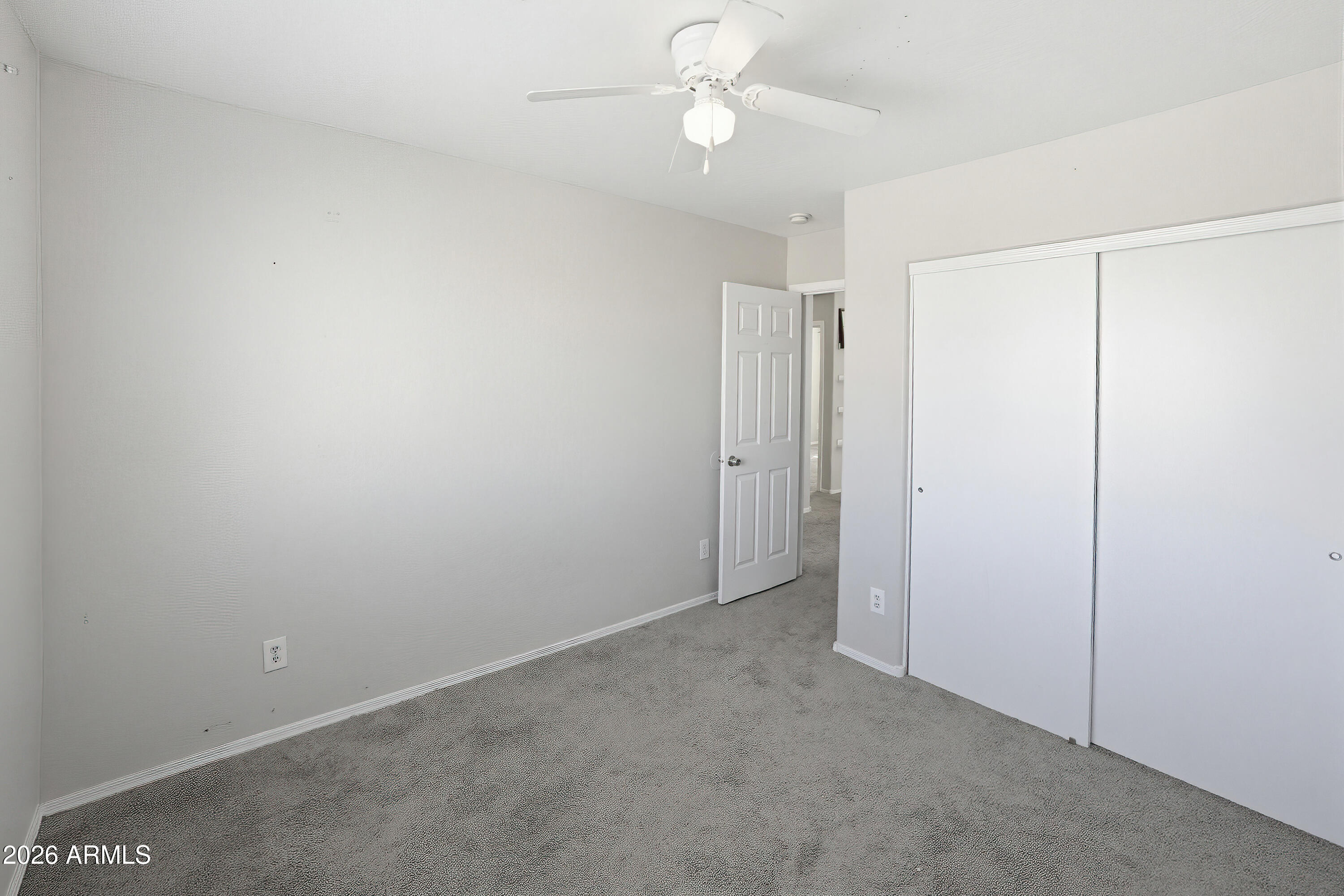 3818 West Carson Road Phoenix, AZ 85041 - Photo 19 of 41 an empty room with a ceiling fan and a window