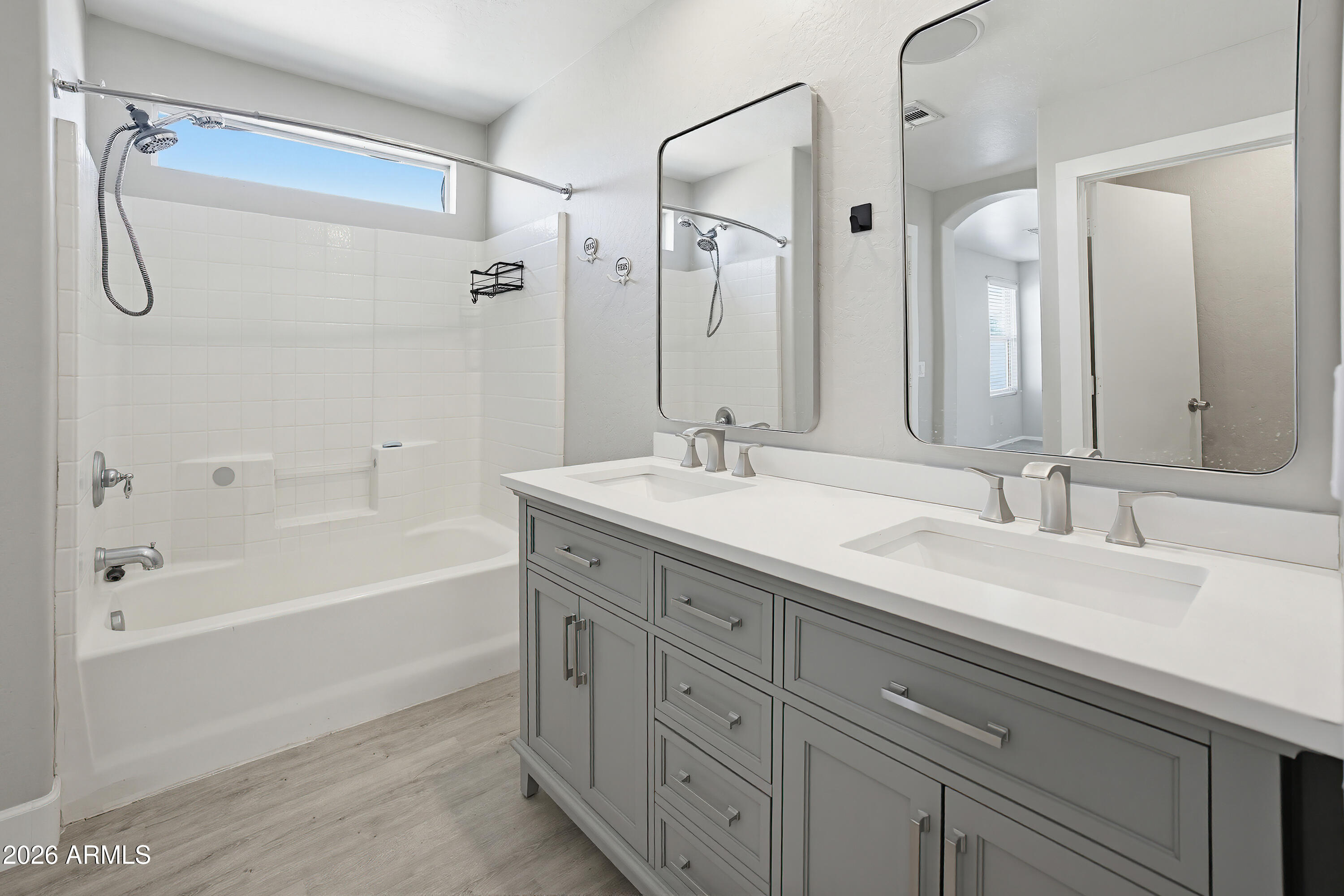 3818 West Carson Road Phoenix, AZ 85041 - Photo 25 of 41 a bathroom with a granite countertop sink a mirror a shower and a bathtub