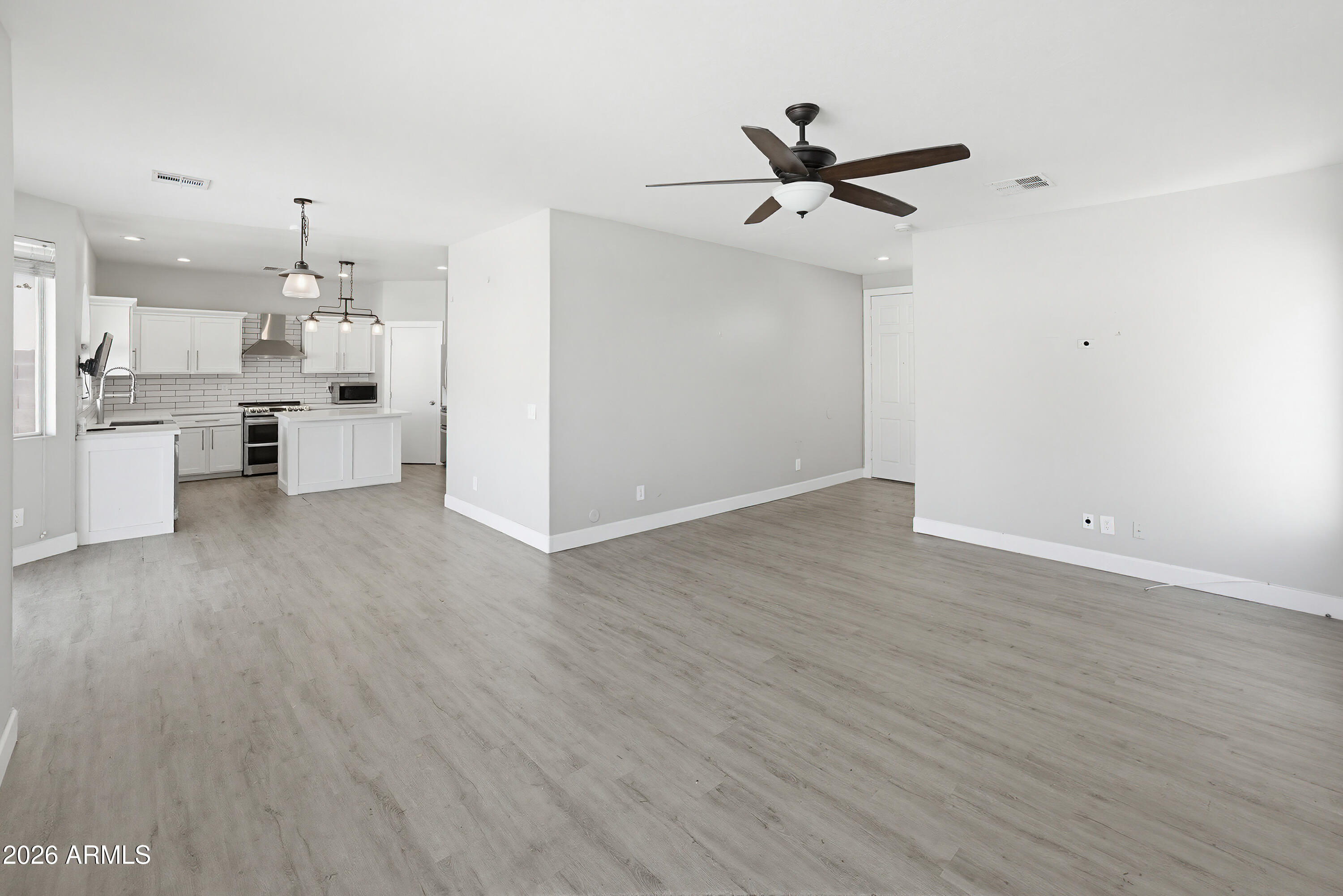 3818 West Carson Road Phoenix, AZ 85041 - Photo 8 of 41 a view of a kitchen with wooden floor and a ceiling fan