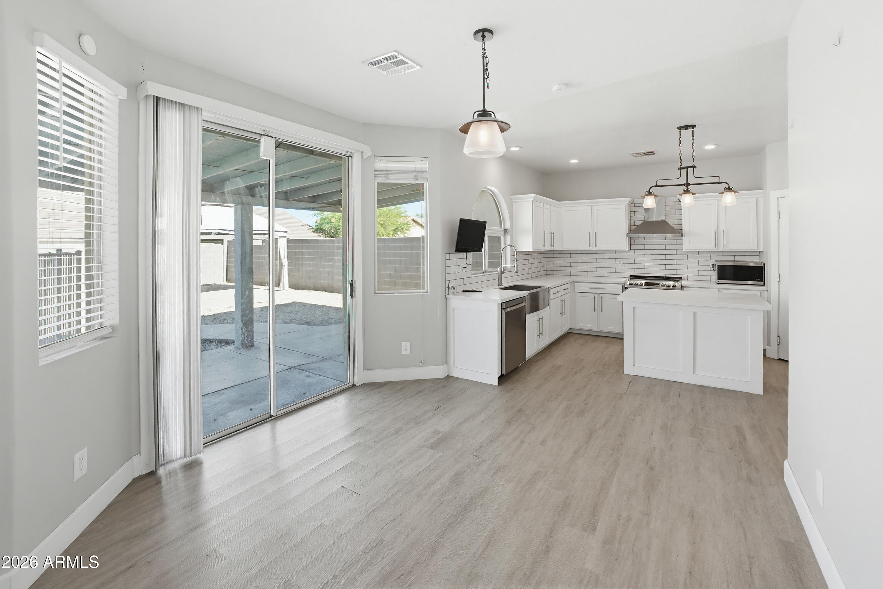 3818 West Carson Road Phoenix, AZ 85041 - Photo 9 of 41 a large kitchen with cabinets wooden floor and stainless steel appliances