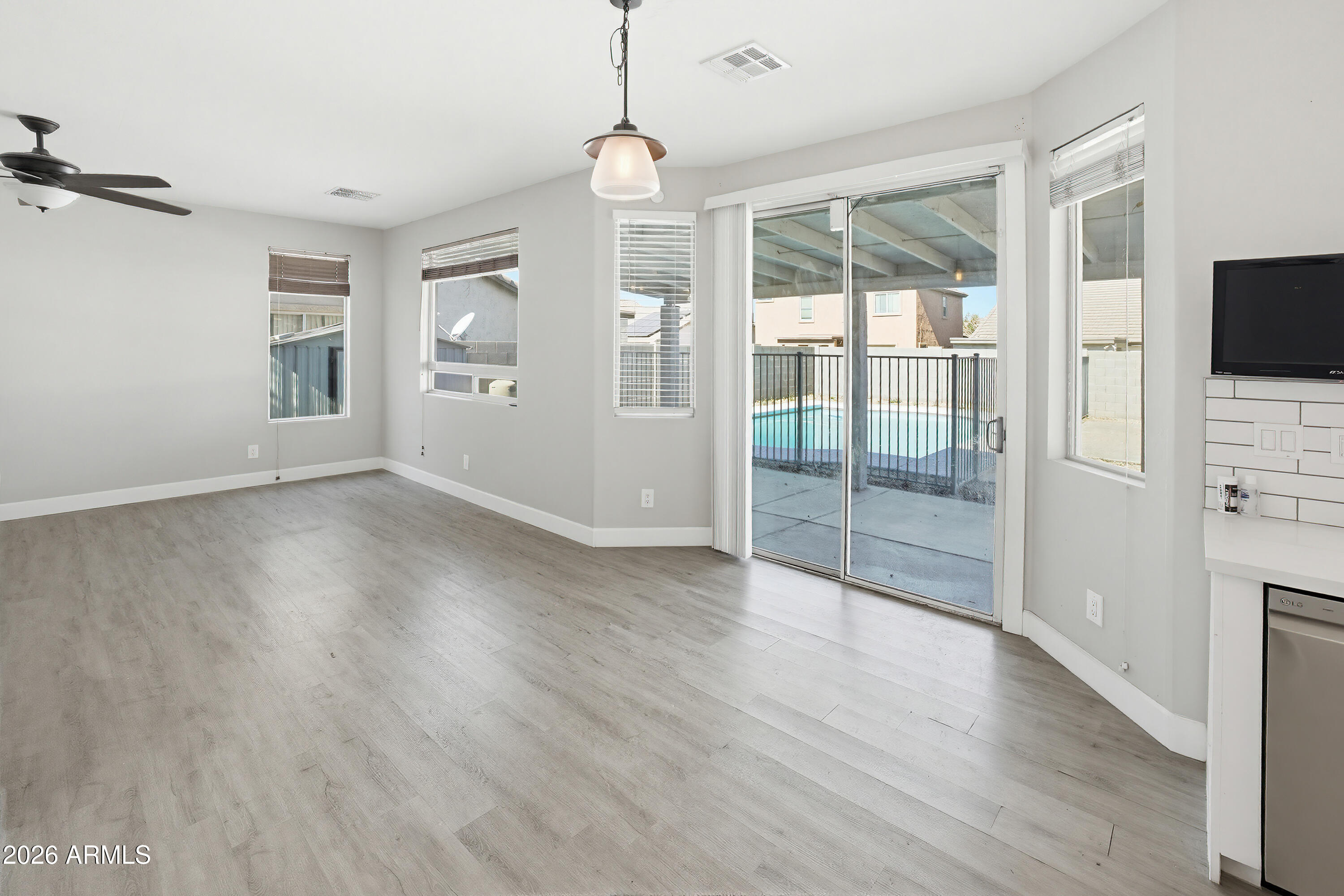 3818 West Carson Road Phoenix, AZ 85041 - Photo 10 of 41 a view of an empty room with wooden floor and a window