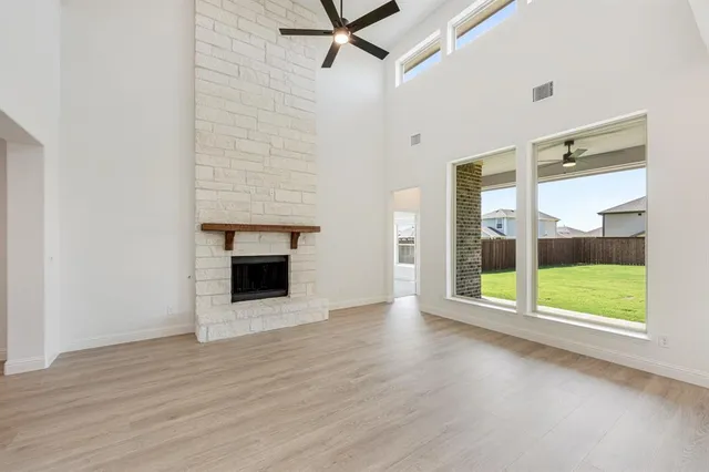 wooden floor fireplace and windows in an empty room
