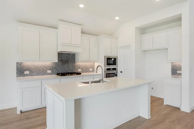 a kitchen with kitchen island a stove a sink and a refrigerator