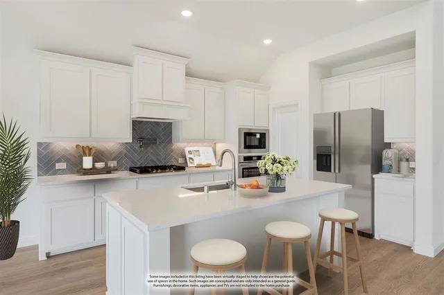 a kitchen with stainless steel appliances granite countertop a sink a stove a refrigerator cabinets and chairs