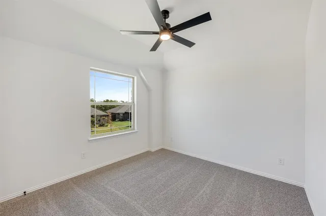 an empty room with a window and a ceiling fan