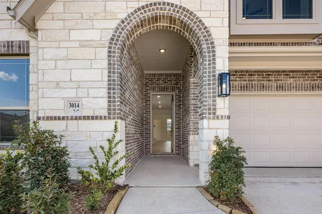 a front view of a house with plants