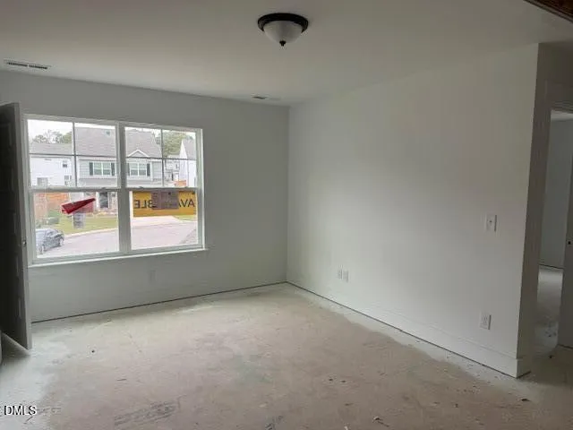 a view of an empty room with a fireplace and a window
