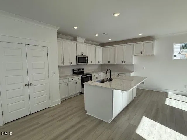 a kitchen with appliances a sink and cabinets