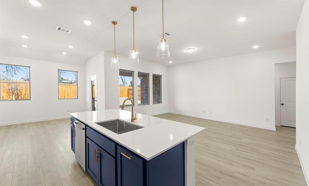 906 Colgate Circle Princeton, TX 75407 - Photo 8 of 16 a kitchen with a sink chandelier and wooden floor