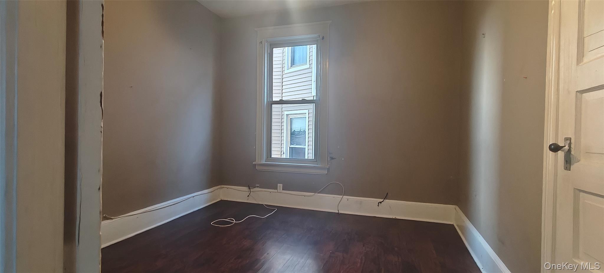 27 Franklin Street, Unit 1F Poughkeepsie, NY 12601 - Photo 2 of 7 an empty room with wooden floor and windows