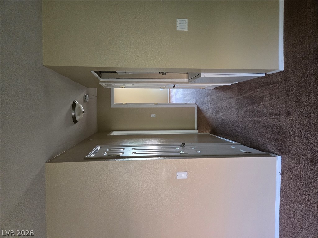 7200 West Pirates Cove Road, Unit 2047 Las Vegas, NV 89145 - Photo 7 of 17 A well-maintained interior hallway features clean walls and soft carpeting leading to multiple rooms.