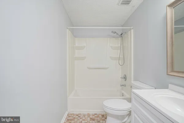 a bathroom with a granite countertop toilet a sink and a bathtub