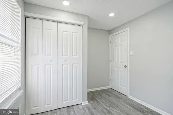 an empty room with wooden floor and closet area
