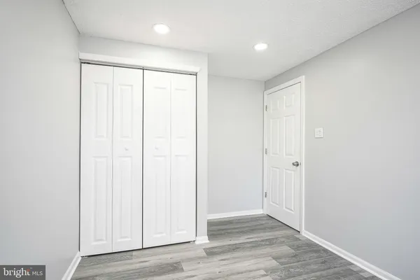 an empty room with wooden floor and entryway