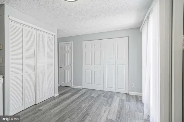 an empty room with wooden floor and closet area