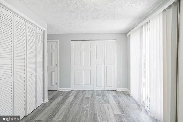 an empty room with wooden floor and closet area