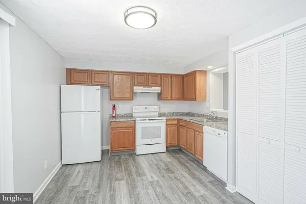 a kitchen with a refrigerator sink and cabinets