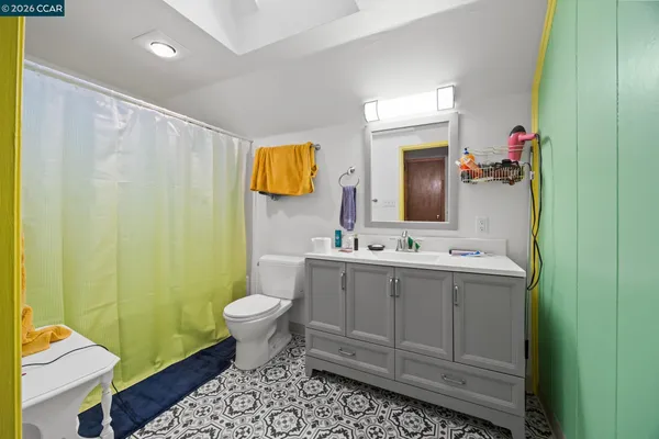 a bathroom with a sink vanity mirror and toilet