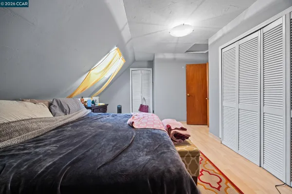 a bedroom with a bed and a dresser next to a window
