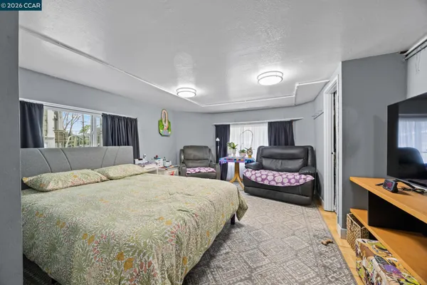 a spacious bedroom with a bed and dresser