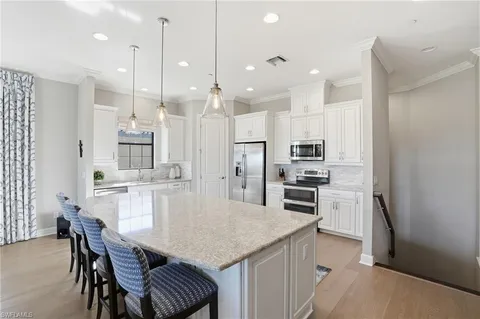 a kitchen with stainless steel appliances granite countertop a kitchen island hardwood floor and a sink