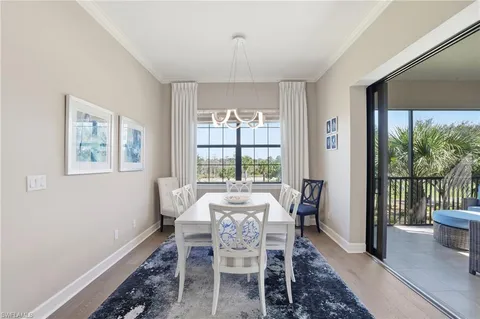 a dining room with furniture window and wooden floor