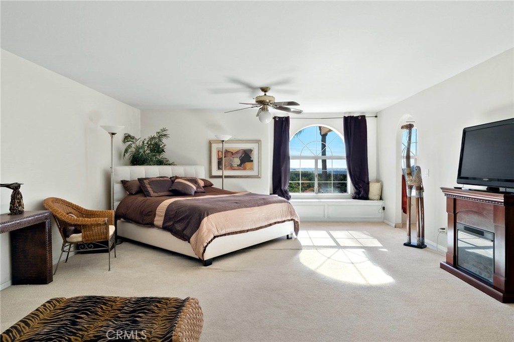 334 Rainbow Crest Road Fallbrook, CA 92028 - Photo 32 of 42 a spacious bedroom with a bed flat screen tv and a large window