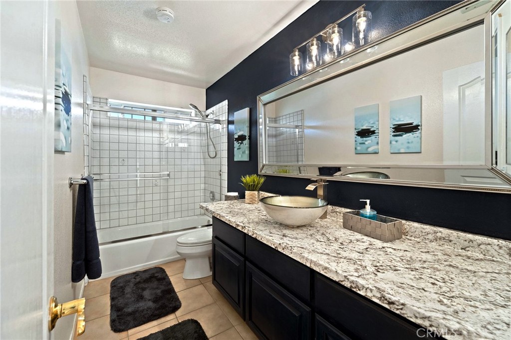 334 Rainbow Crest Road Fallbrook, CA 92028 - Photo 39 of 42 a bathroom with a granite countertop sink a toilet a mirror and shower