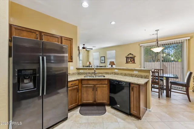 a kitchen with stainless steel appliances granite countertop a sink and a refrigerator