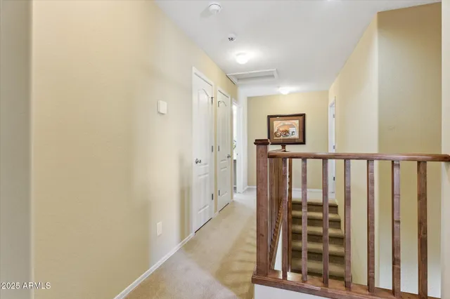 a view of a hallway with wooden floor and a bathroom