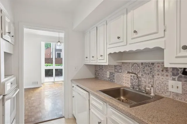 a kitchen with granite countertop white cabinets and sink