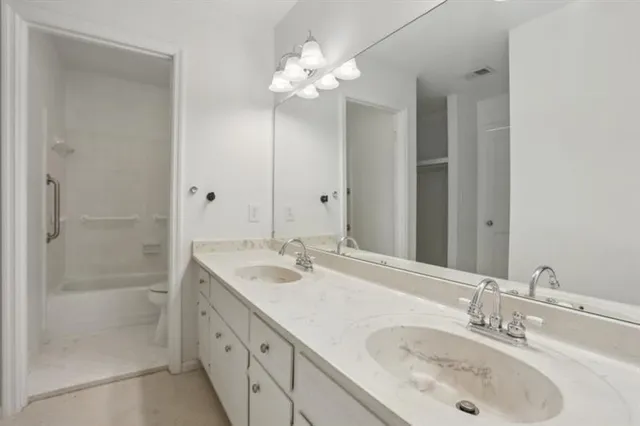 a bathroom with double vanity and a mirror