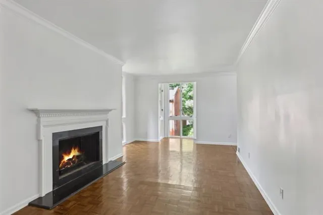 a view of an empty room with a fireplace and a window