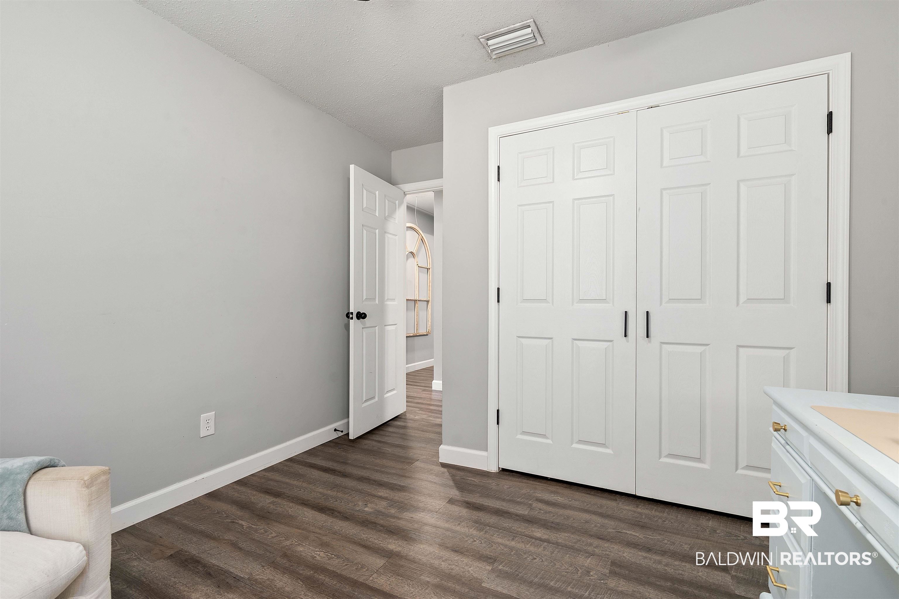 4682 Opal Drive Mobile, AL 36619 - Photo 17 of 27 Bedroom with a closet and dark hardwood / wood-style flooring
