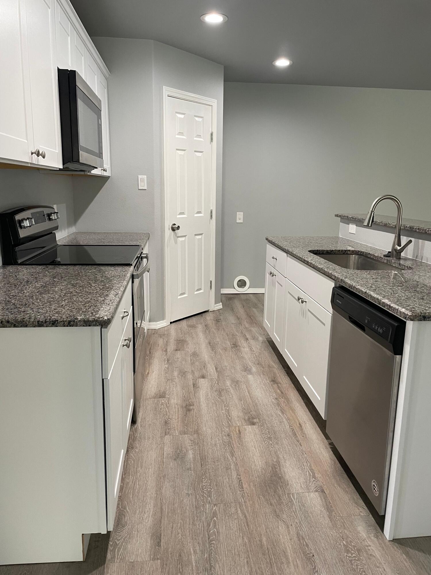 1301 North Colton Avenue, Unit A Lubbock, TX 79416 - Photo 4 of 9 a kitchen with granite countertop a sink stove and cabinets