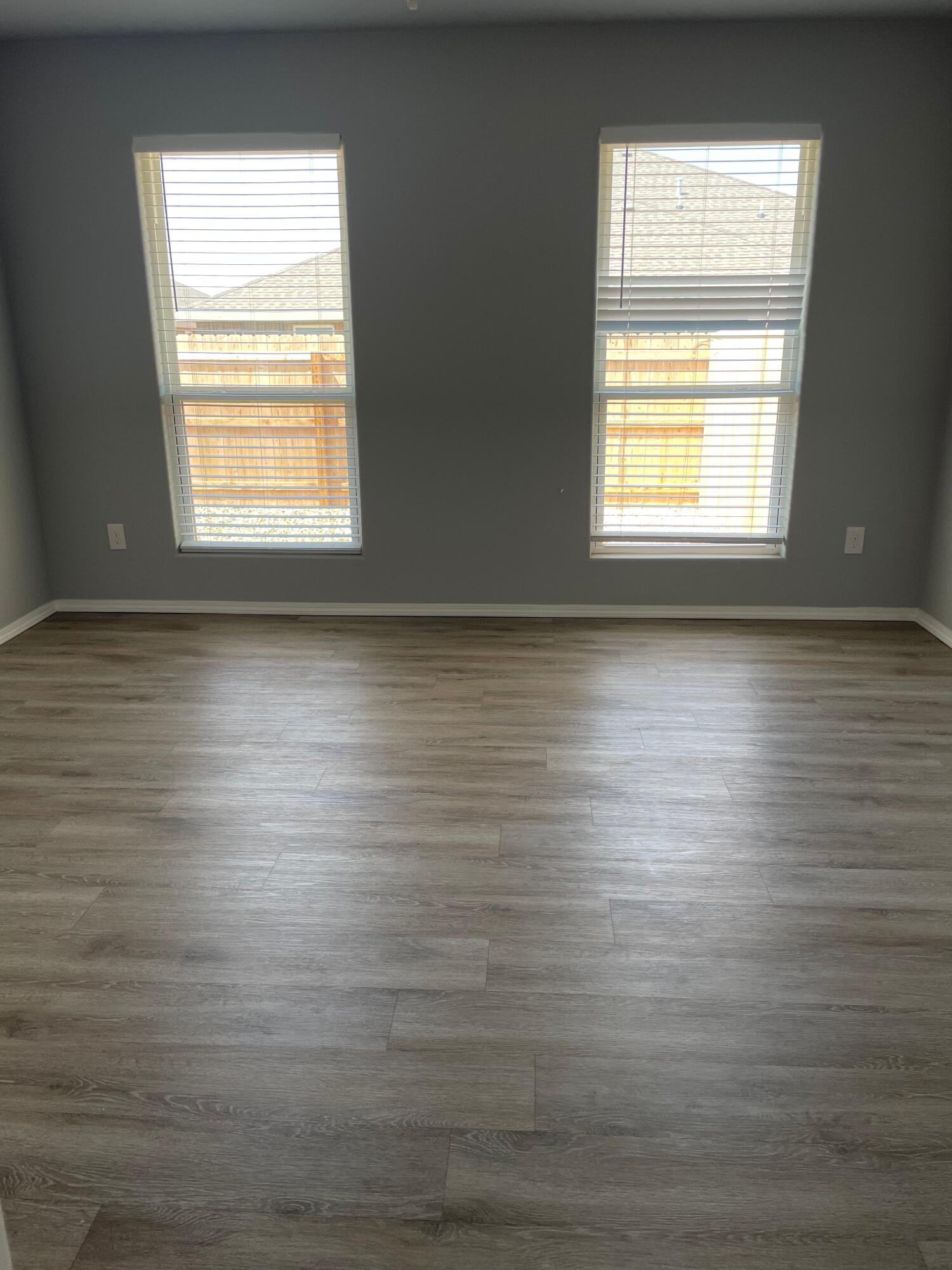 1301 North Colton Avenue, Unit A Lubbock, TX 79416 - Photo 6 of 9 an empty room with wooden floor and windows