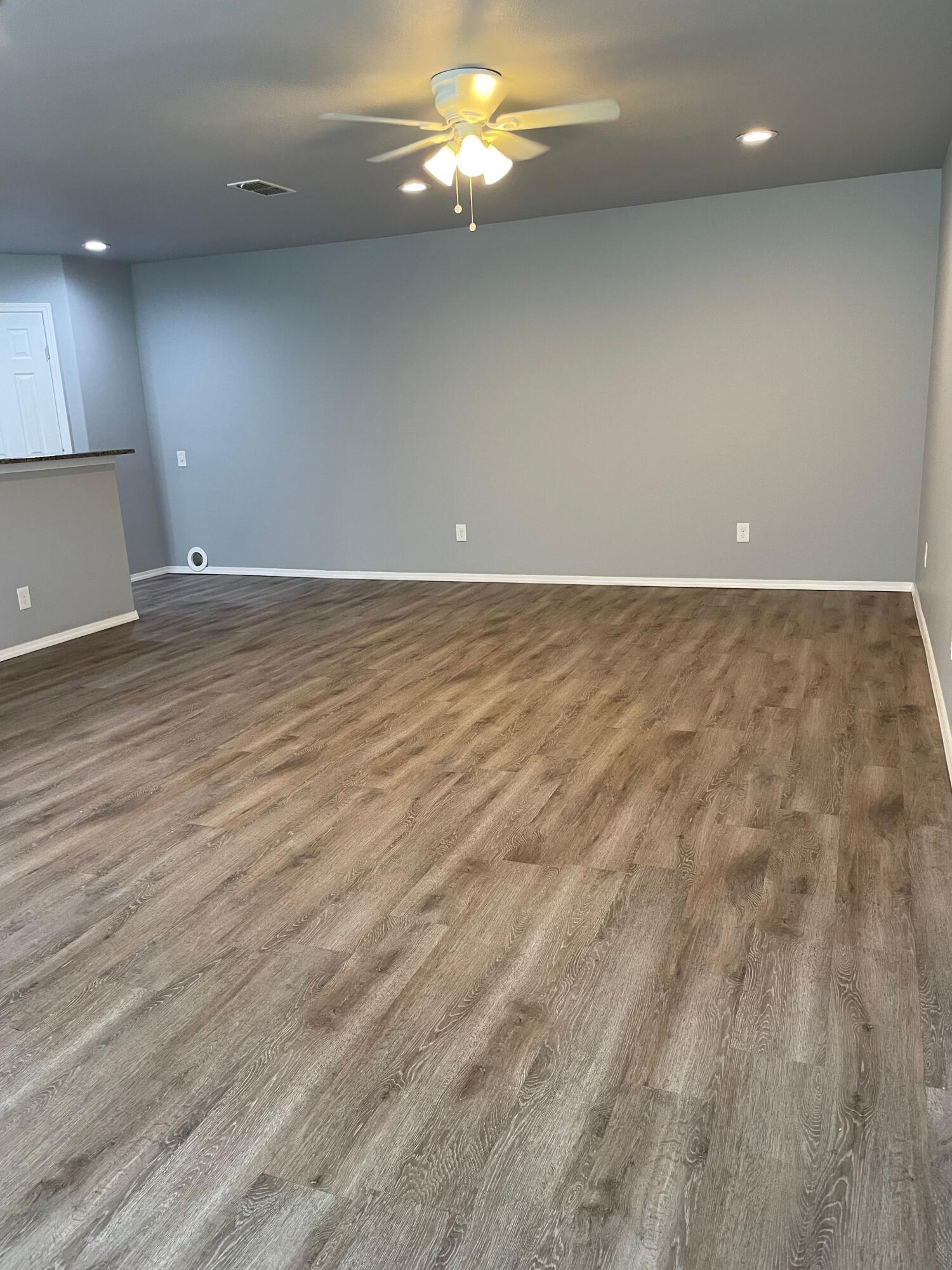 1301 North Colton Avenue, Unit A Lubbock, TX 79416 - Photo 8 of 9 an empty room with wooden floor and fan