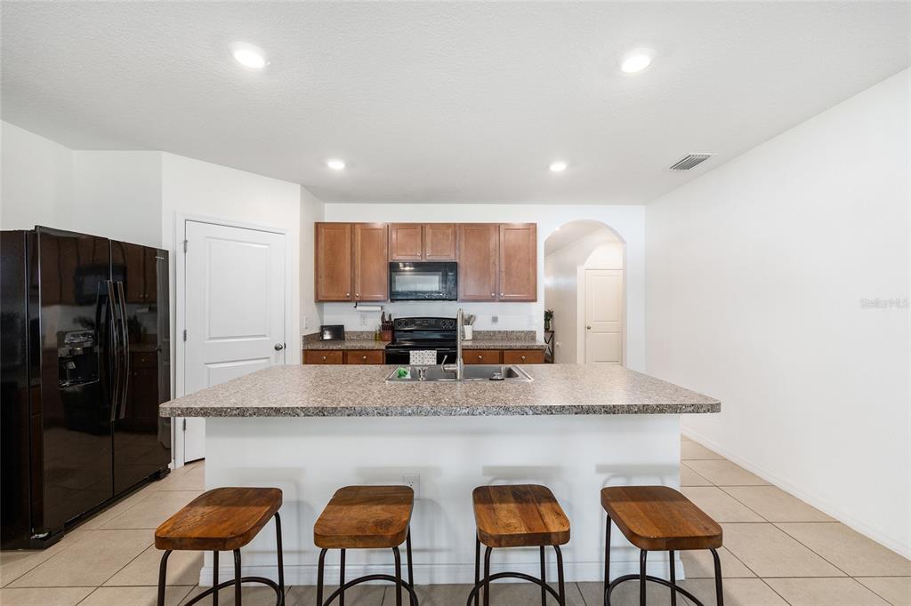 2530 Northeast 42nd Road Ocala, FL 34470 - Photo 12 of 61 a kitchen with stainless steel appliances granite countertop a table chairs sink refrigerator and microwave