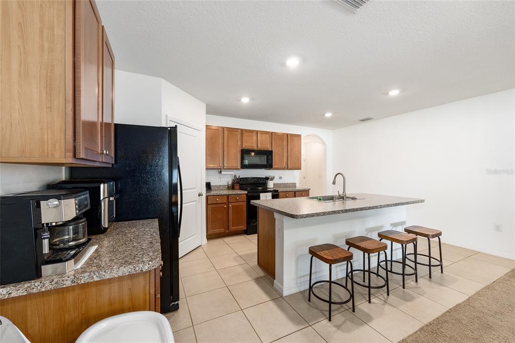 2530 Northeast 42nd Road Ocala, FL 34470 - Photo 13 of 61 a kitchen with stainless steel appliances granite countertop a stove top oven a sink a dining table and chairs