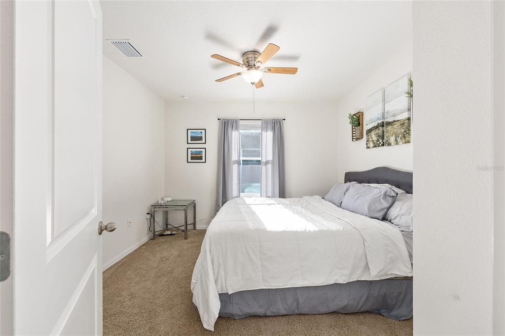 2530 Northeast 42nd Road Ocala, FL 34470 - Photo 31 of 61 a bedroom with a large bed and a chandelier