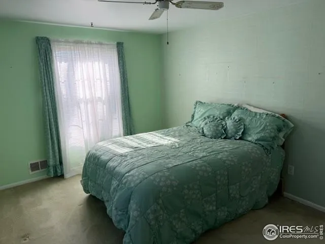a large bed sitting in a bedroom next to a window