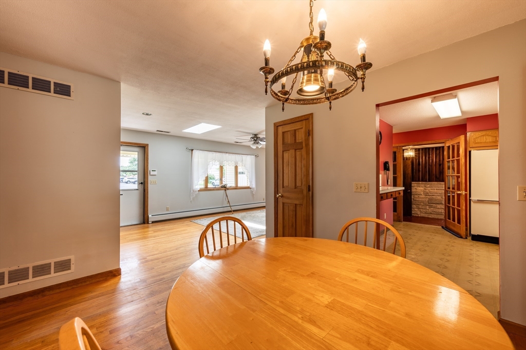 36 Gunn Road Southampton, MA 01073 - Photo 16 of 40 a dining room with wooden floor a chandelier a wooden table and chairs