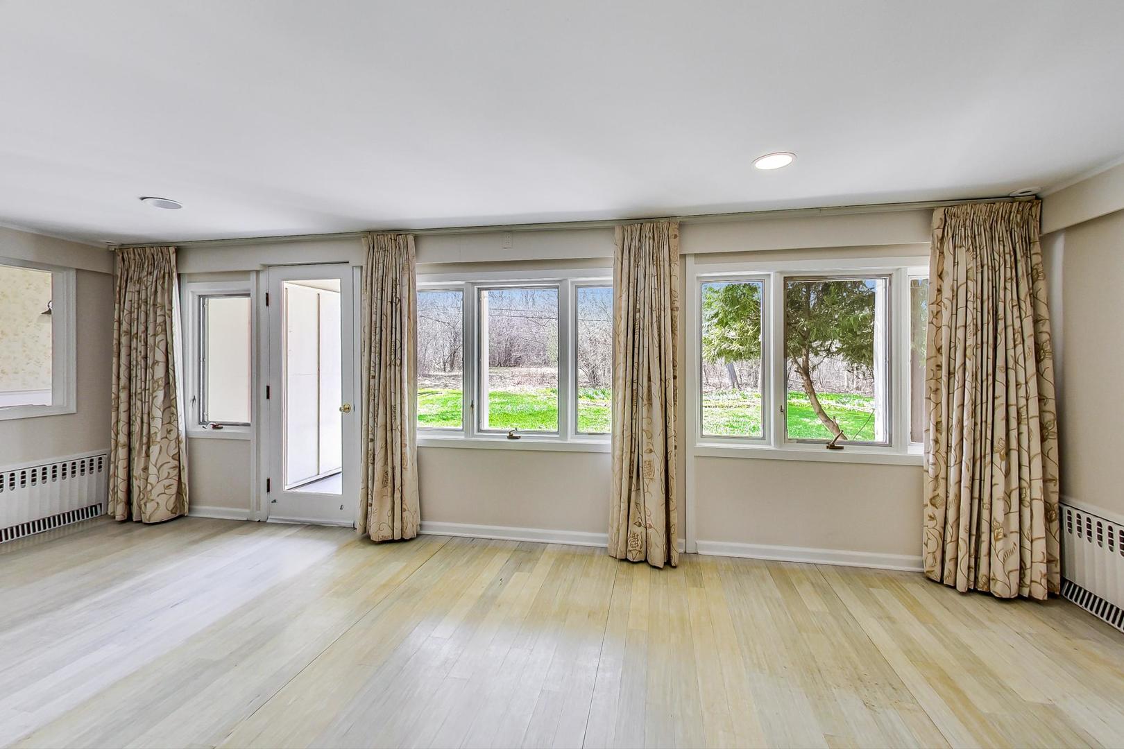 22 Timber Lane Northbrook, IL 60062 - Photo 13 of 41 a view of an empty room with a window and wooden floor