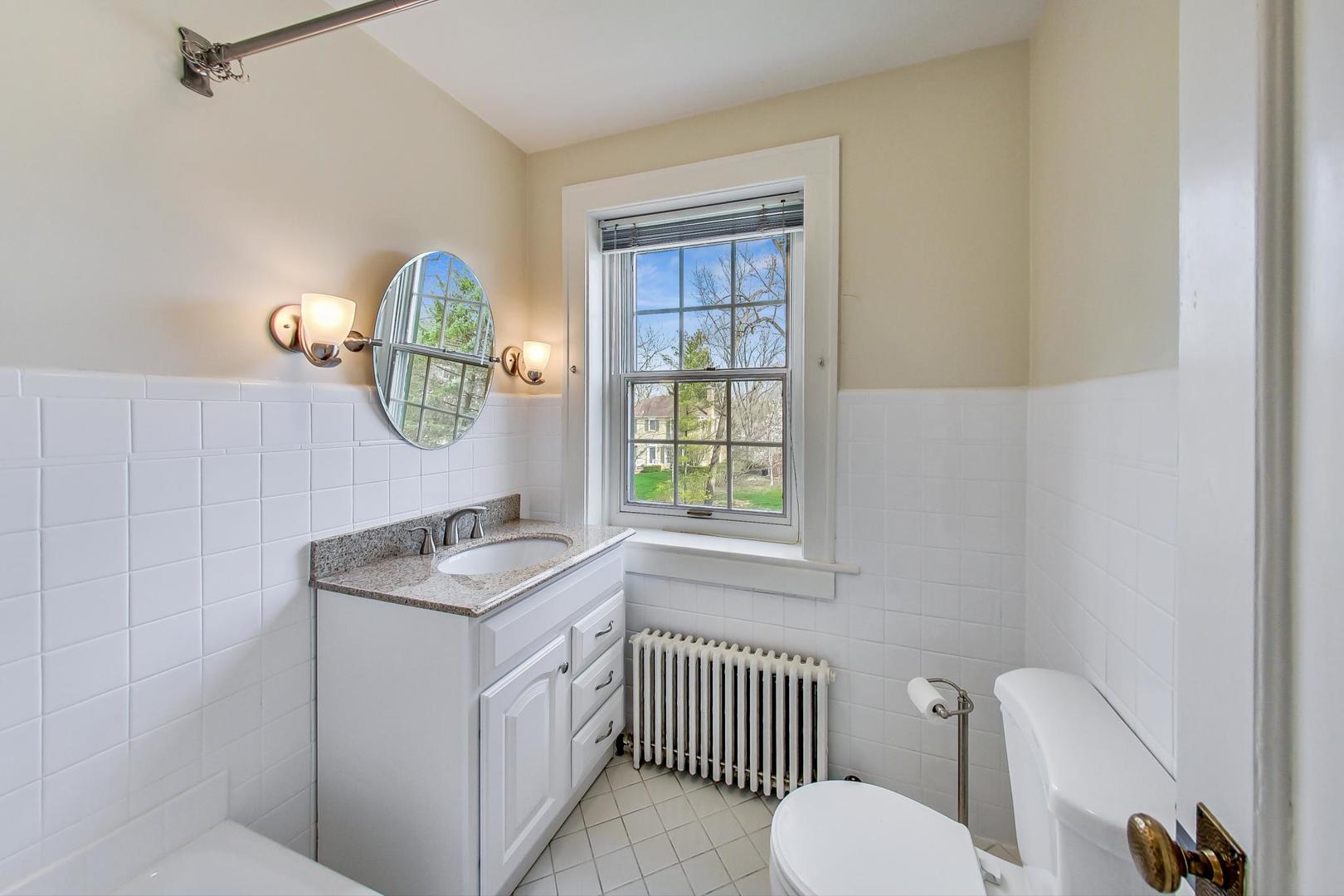 22 Timber Lane Northbrook, IL 60062 - Photo 17 of 41 a bathroom with a toilet a sink and a window