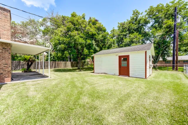 a view of a house with backyard and tree