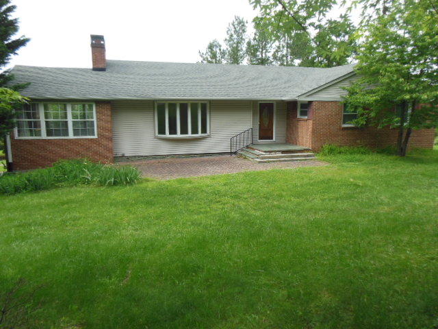 a front view of a house with yard and green space