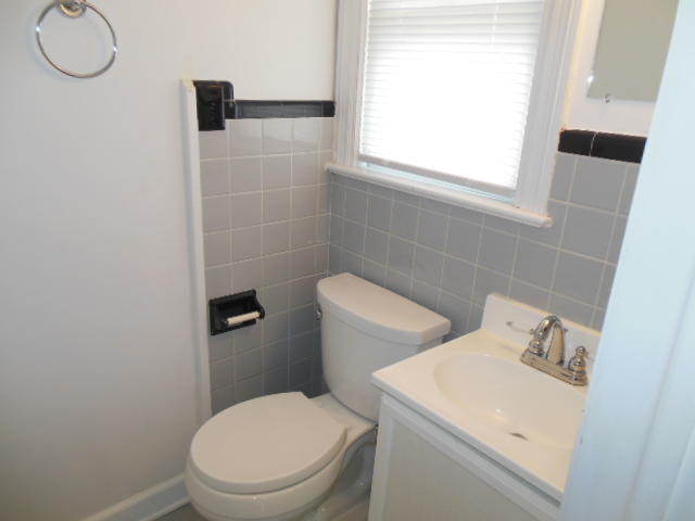 4645 Grandin Road Southwest Roanoke, VA 24018 - Photo 14 of 23 a white toilet sitting next to a bathroom sink