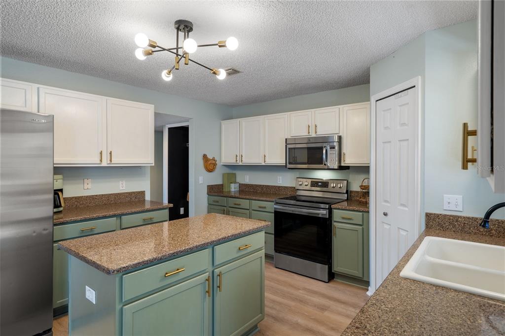 11258 Lomita Wren Road Weeki Wachee, FL 34614 - Photo 13 of 44 a kitchen with stainless steel appliances granite countertop a stove cabinets and refrigerator