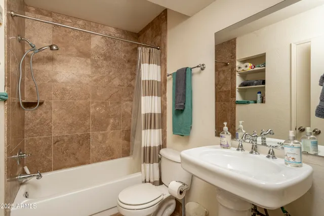 a bathroom with a sink a toilet and shower